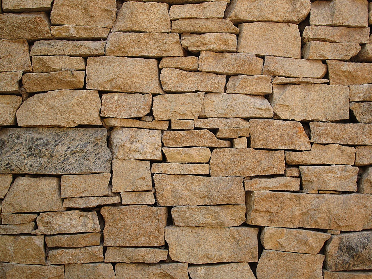 Close-up of a rustic stone wall showcasing natural colors and textures.